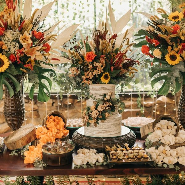 table setting featuring a wedding cake and pastries, decorated with fall wedding flowers
