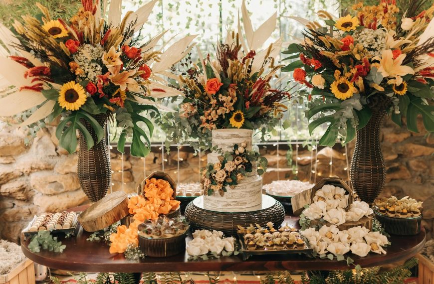 table setting featuring a wedding cake and pastries, decorated with fall wedding flowers