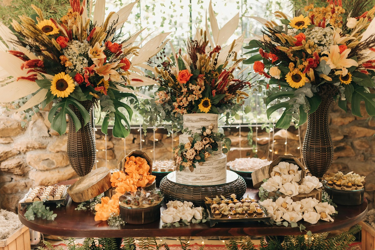 table setting featuring a wedding cake and pastries, decorated with fall wedding flowers